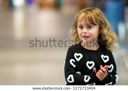 3-4 year old girl looking and smiling with interest something Royalty-Free Stock Photo #1272713404
