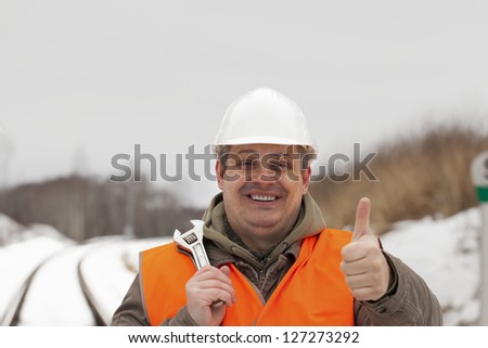 Smiling railroad worker with outstretched hand with thumb up