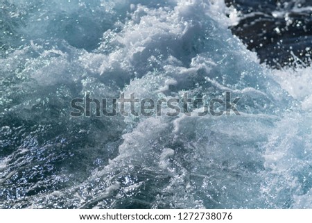 Turbulence at sea with breaking surf and white water in a close up view on the spray