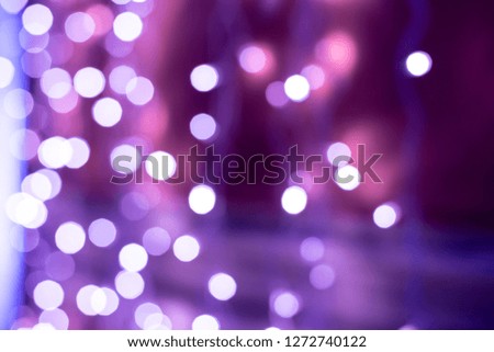 Purple bokeh blurred lights background. Violet garlands decoration for the new year celebration.