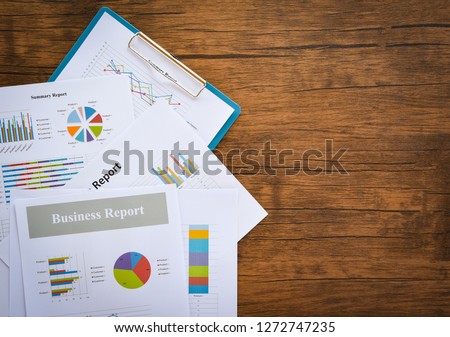 Business report chart preparing graphs concept / Summary report in Statistics circle Pie chart on paper business document financial chart and graph on the wooden table background 