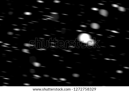 white dots snow in motion on a black background blurry