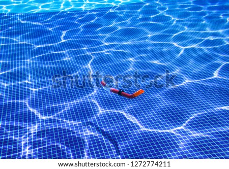 Underwater shot of a snorkel sinking in a swimming pool