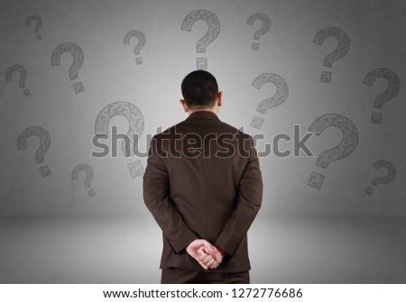 Rear view of businessman with question marks, thinking gesture over grunge background, tring to find idea to solve problem