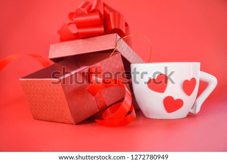 Open Gift Box decorate with ribbon bow  and white Coffee cup with red heart / for gift to Merry Christmas Holiday Happy new year or Valentines day on red background 
