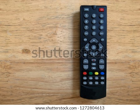 television remote control on wooden table.