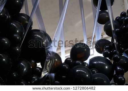 Big and small black balloons background, in the factory building