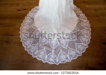 Detail of wedding dress lace against wooden floor