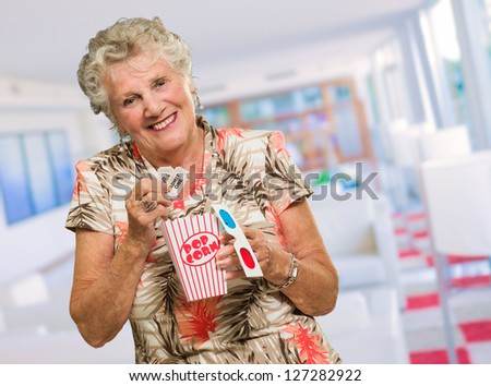 Senior Woman Holding 3d Glasses And Popcorn, Indoors