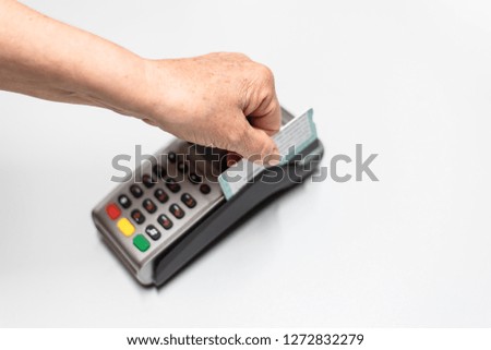 Woman's hand passing credit card by a dataphone, card reader to charge in time of sales.