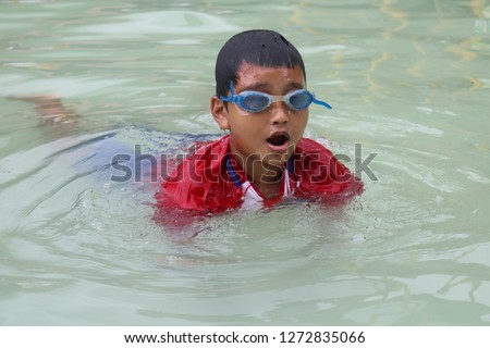 Asian children are swimming in the pool using swimming goggles