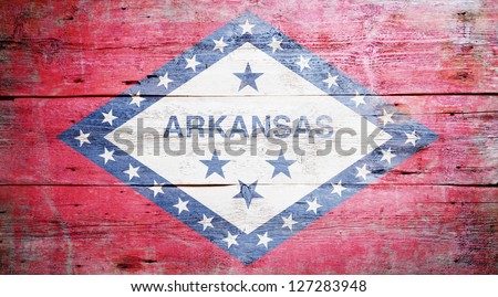 Flag of Arkansas painted on grungy wooden background