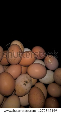 Many type of fresh eggs have white duck eggs and yellow chicken on black background. On the farmer's farm that is stored for family consumption and for sale. Close up, top view.