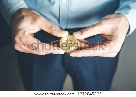 man hand holding bitcoins on dark background