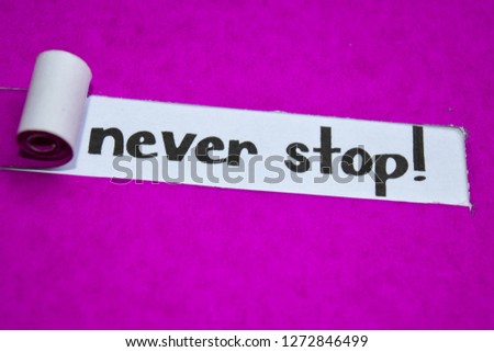 Never Stop! text, Inspiration, Motivation and business concept on purple torn paper