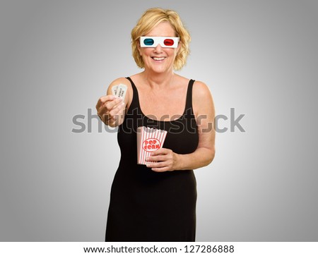 Happy Elderly Woman Wearing 3d Glasses Holding Popcorn And Ticket On Grey Background