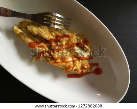 Top view picture of omelet on white plate.