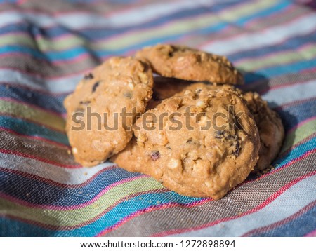 Cookies raisin and macadamia nuts on nature background and stripe fabric texture