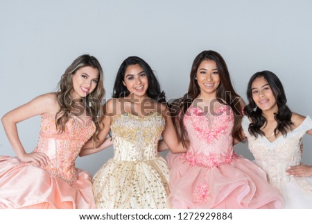 Group of four happy hispanic teenage girls in their quinceanera dresses