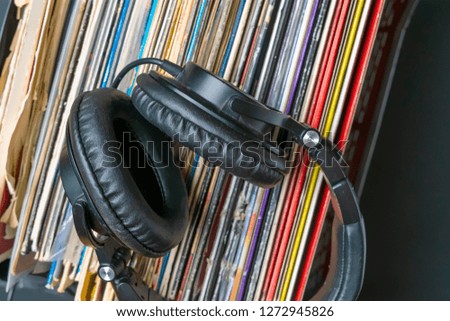 dark headphones lay on stack of retro vinyl records