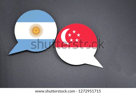 Argentina and Singapore flags with two speech bubbles on dark gray background