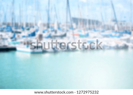 Abstract blur background  seaside port with boat floating on aqua sea with background building ,white clouds and blue sky, environment in nord france, europe. 