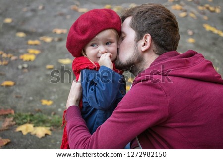 Dad is kissing his crying daughter. Close up, autumn time.