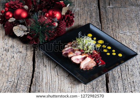 Duck breast, chopped with slices and beautifully presented with cherry sauce.