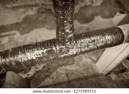 Basement apartment house. Water supply pipe. Completed repair tee. Picture taken in Ukraine. Kiev region. Horizontal frame. Black and white image. Sepia