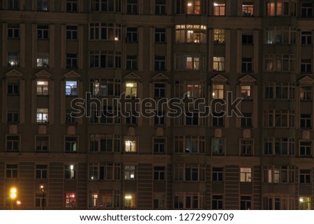 Glowing apartment windows at night where each occupant has his own privacy 