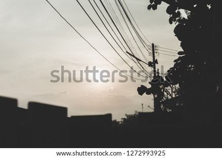 The sky, the sun, and the electric poles of the house in a dark tone,abstract image.
