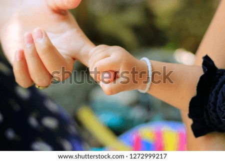 Close to the child is holding an adult hand.