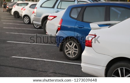 Closeup of rear or back side of white car with  other cars parking in parking area in the evening of sunny day. The mean of simply transportation in modern world. Royalty-Free Stock Photo #1273039648