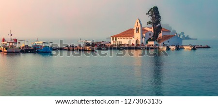 Foggy sunrise of Vlacherna Monastery. Picturesque morning cityscape of Kerkira town, capital of Corfu island, Greece, Europe. Panoramic summer seascape of Ionian Sea. Traveling concept background.