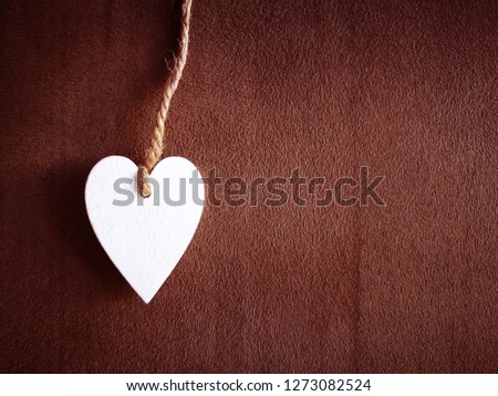 White heart with rope on brown background with copy space. Sepia photo. Valentine concept. 