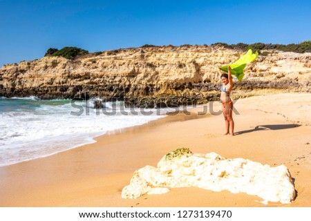 Young girl playing with towel on the beach praia da Albandeira, Algarve, Portugal
