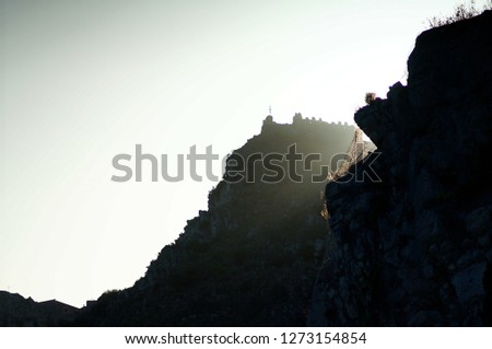 Ancient Sicilian Castle at a Huge Height Above Perilous Cliff Face at Strong Dark Sunset