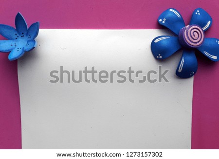 white sheet with pink background and two blue rubber flowers on each corner