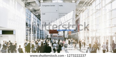 crowd of trade fair visitors walking in a clean futuristic corridor