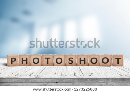 Photoshoot word sign on a wooden desk with a blurry background of a photo studio