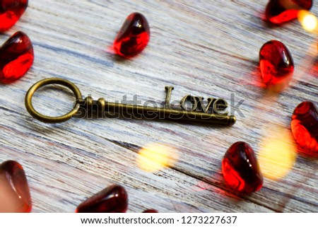 bronze retro key with the word love on a white wooden background, place under the text, card for Valentines day, holiday concept, bokeh
