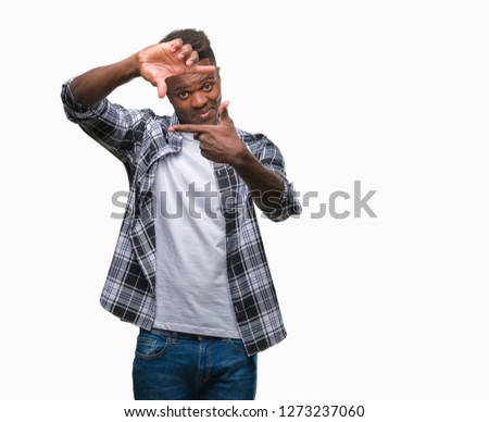 Young african american man over isolated background smiling making frame with hands and fingers with happy face. Creativity and photography concept.