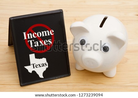 No income tax in the state of Texas message with a piggy bank on a retro freestanding chalkboard on a wood desk