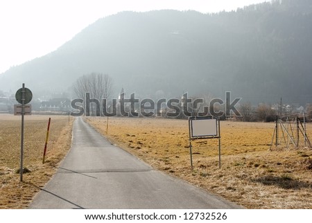 Rural road with empty signboard