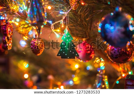 New Year. Christmas tree. A toy in the shape of a ball, pine, beads and garland lights. Picture taken in Ukraine. Kiev region. Horizontal frame. Color image. Soft focus