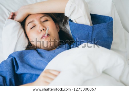 Asian Beautiful Woman Hypothermia has been measured by fever. Lie on the bed to give a body of rehabilitation. The concept of medical care to patients at home by yourself. Royalty-Free Stock Photo #1273300867