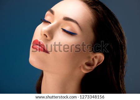 portrait of beautiful woman with glamorous makeup and eyes closed isolated on blue Royalty-Free Stock Photo #1273348156