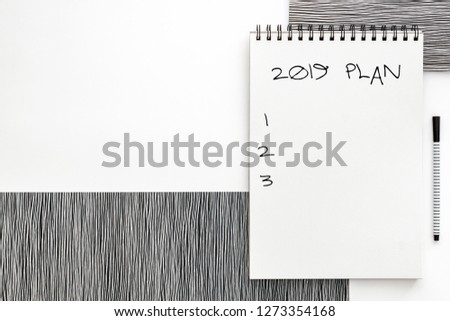 Blank spiral sketchbook with white open page. Top view real photo. White background for text. Copy space. Black and white minimal concept. 2019 plan list
