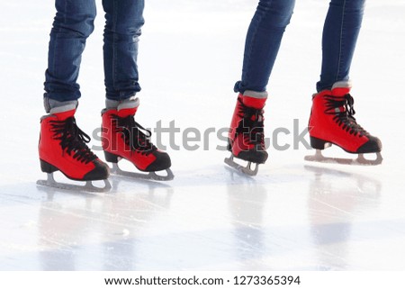 feet in red skates on an ice rink