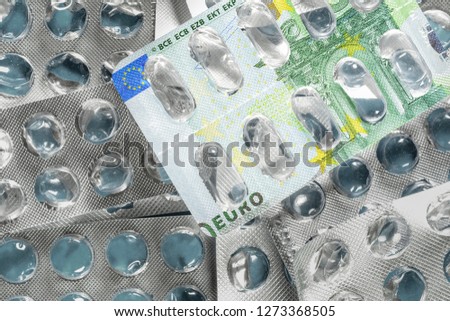 Empty blister pack of pills with 100 euro bill picture. Medical concept of expensive treatment of diseases in Europe.